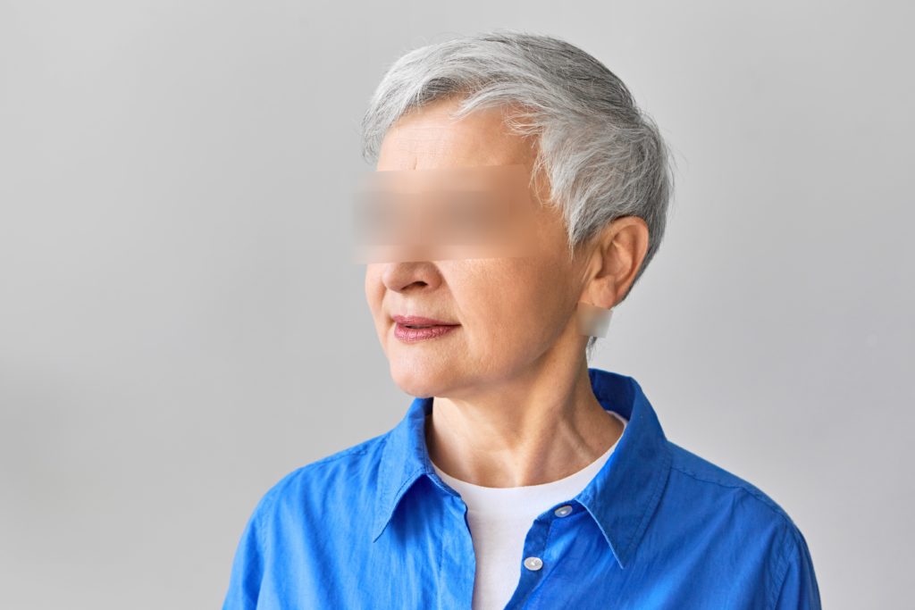 grey haired woman with eyes blurred out