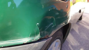 panel of a green car with damage